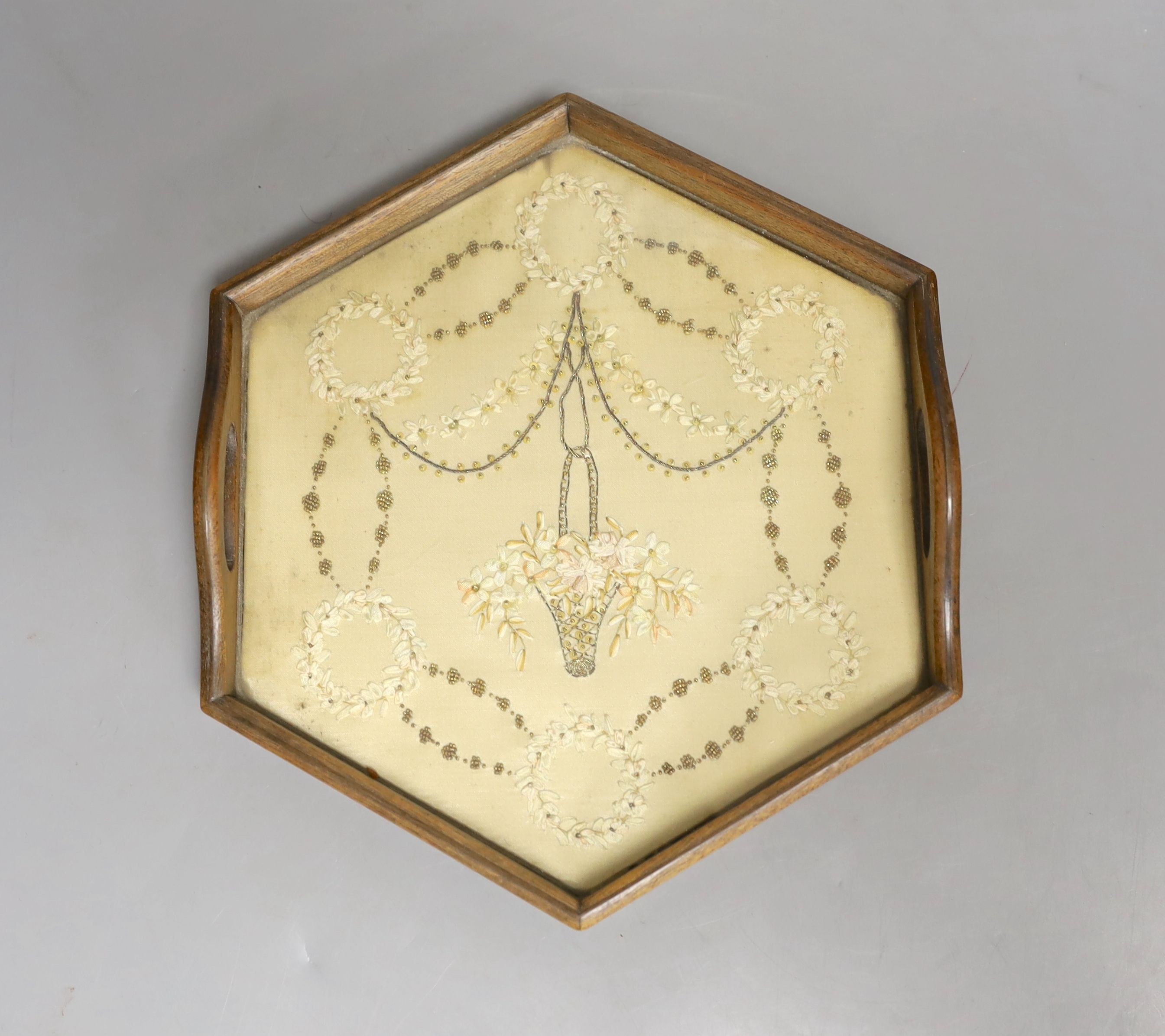 An early Victorian hexagonal tray with ribbon worked embroidery on silk, 25cm